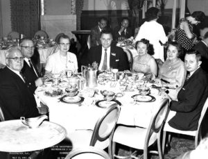 1965 Group of UNA Members taking photo at dinner table