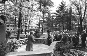 Woman speaking to members in front of Taras Shevchenko bust at Soyuzivka during the 1975 UNA General Meeting