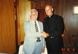 1984 UNA Member shaking hands with priest